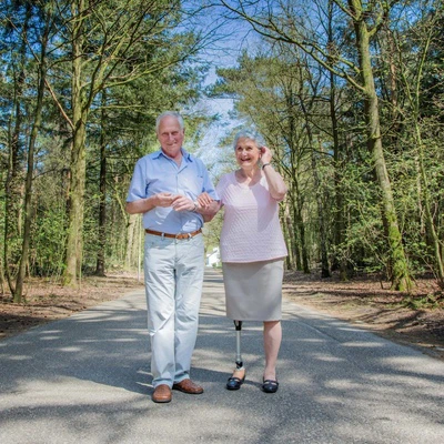Un couple se promène dans la forêt et la femme porte une prothèse de jambe
