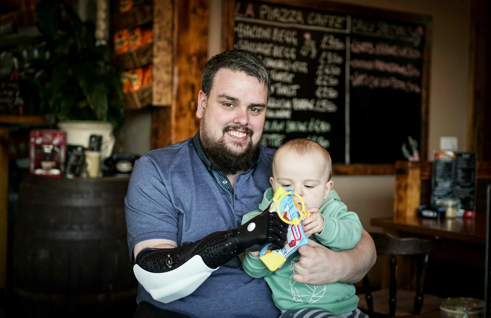 Ouder met armprothese draagt kind dankzij een perfect aangepaste prothese