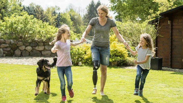 Une famille en train de jouer avec une mère portant une prothèse de jambe
